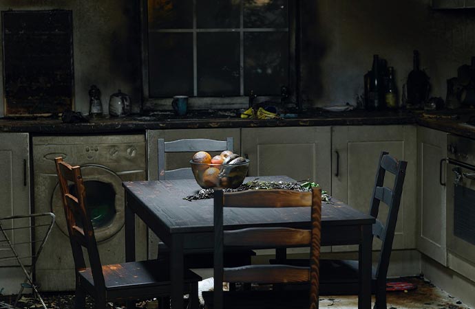 A kitchen interior with significant soot damage